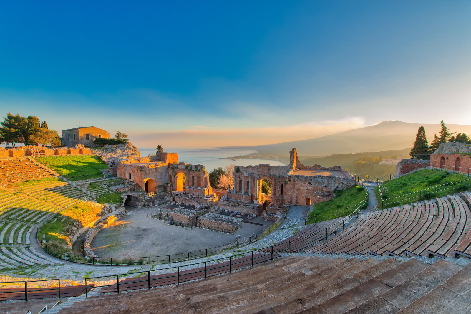Ein antikes Teatro in Taormina, mit Blick auf das Meer und den Ätna im Hintergrund. Schönes Licht beim Sonnenaufgang.