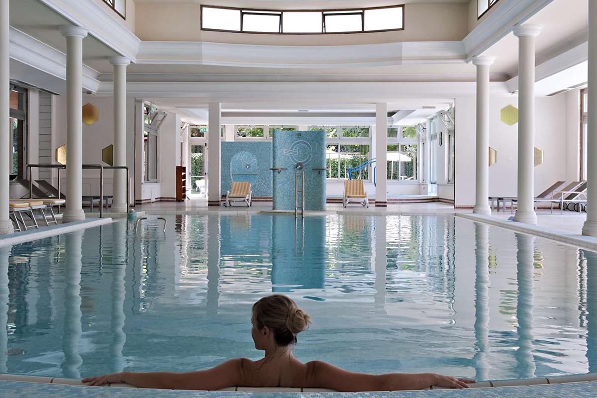 Ein eleganter Wellnessbereich mit einem Schwimmbecken und entspannenden Liegen, ideal für Erholung und Ruhe.