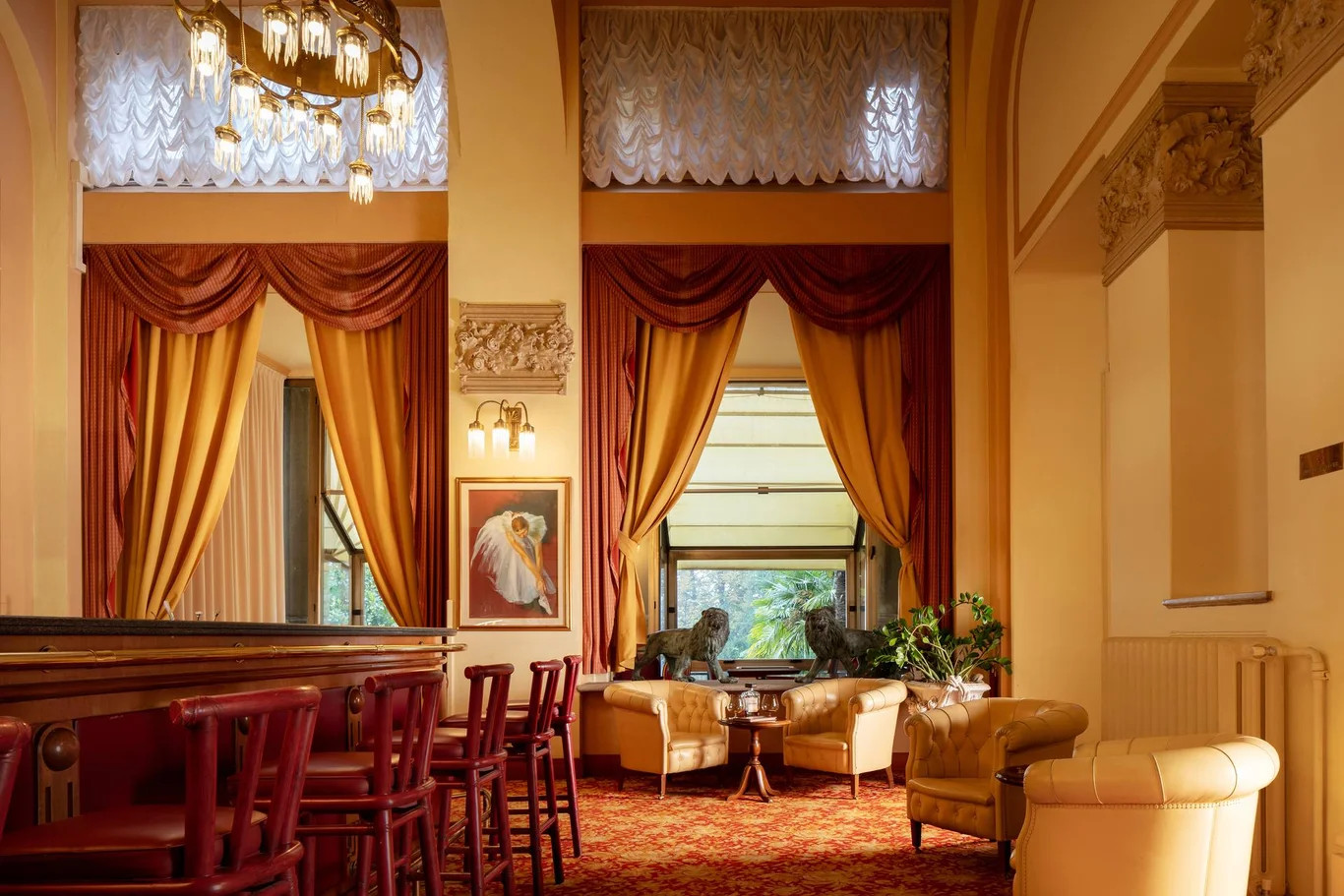 Eleganter Innenraum mit goldenen Vorhängen, einer Bar und gemütlicher Sitzecke, dekoriert mit Tierfiguren.