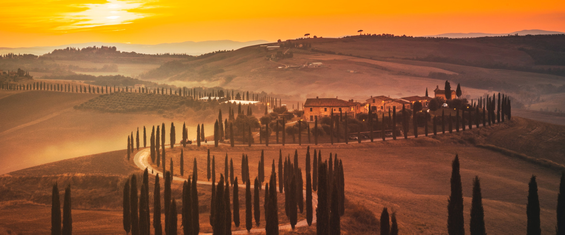 Eine malerische Landschaft in der Toskana bei Sonnenuntergang, mit Zypressen und sanften Hügeln.