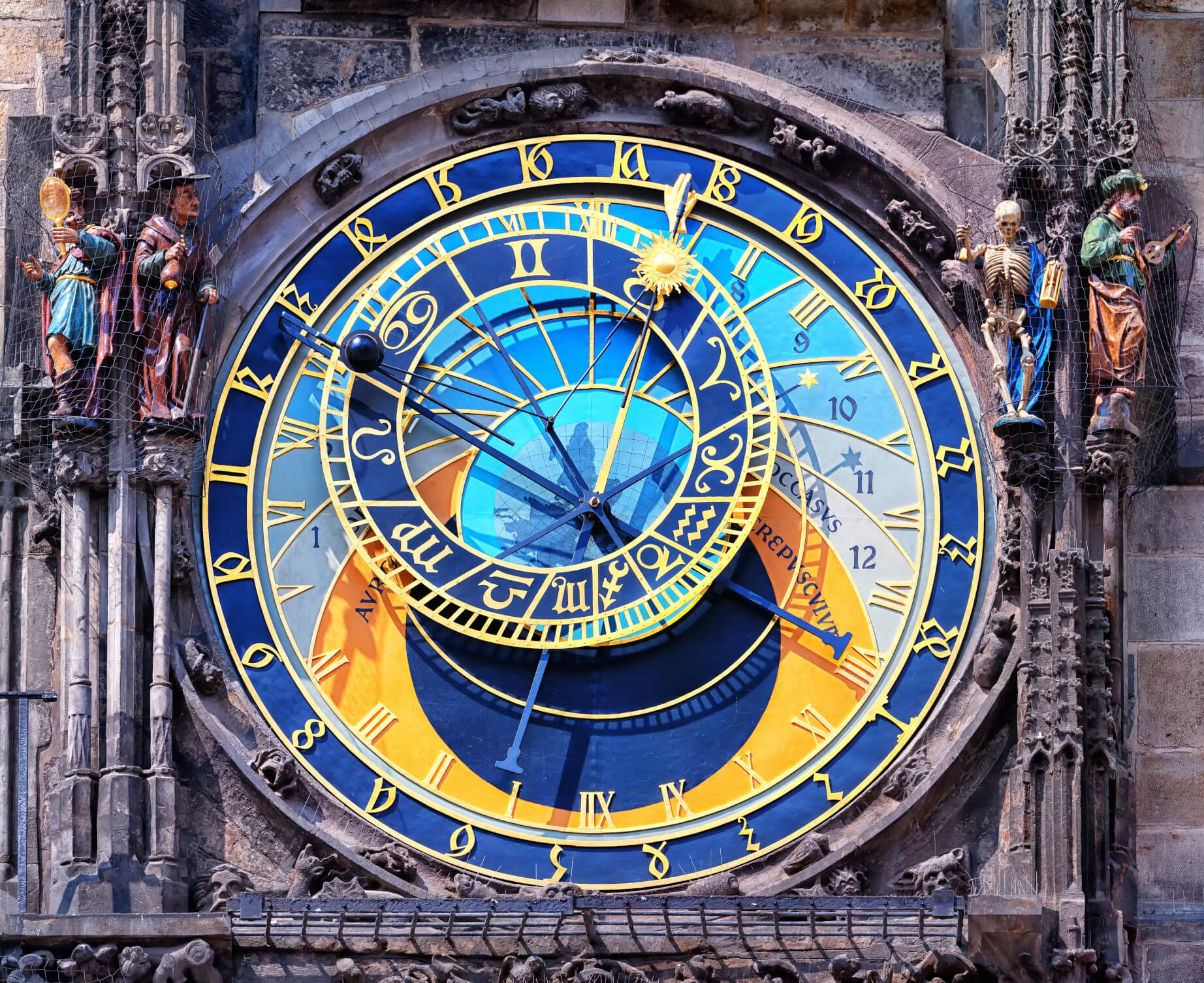 Das Bild zeigt die astronomische Uhr in Prag mit bunten Ziffern und Statuelementen an der Fassade.