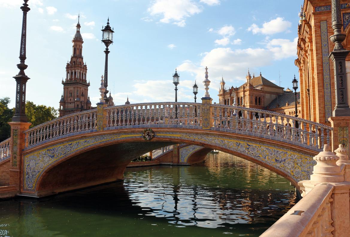 Eine kunstvoll verzierte Brücke überspannt einen ruhigen Kanal, umgeben von historischen Gebäuden und Laternen.