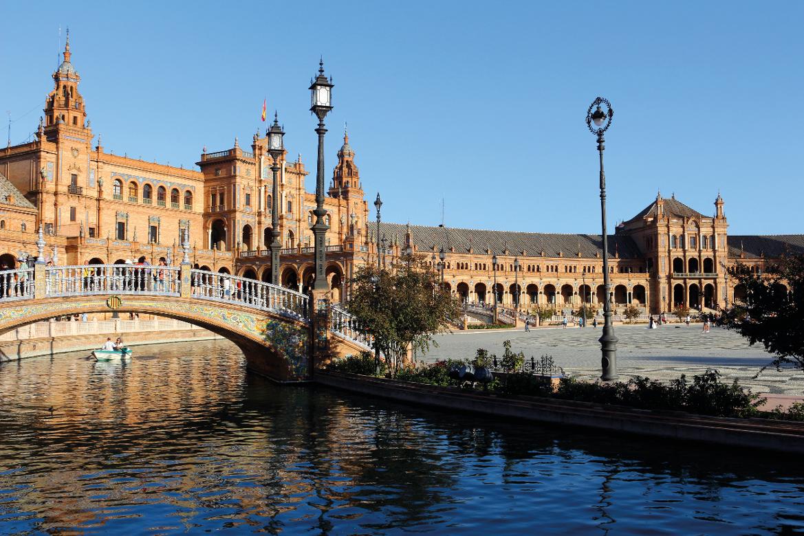 Die Plaza de España mit beeindruckender Architektur und einem malerischen Kanal. Blaues Himmel, sonniger Tag.
