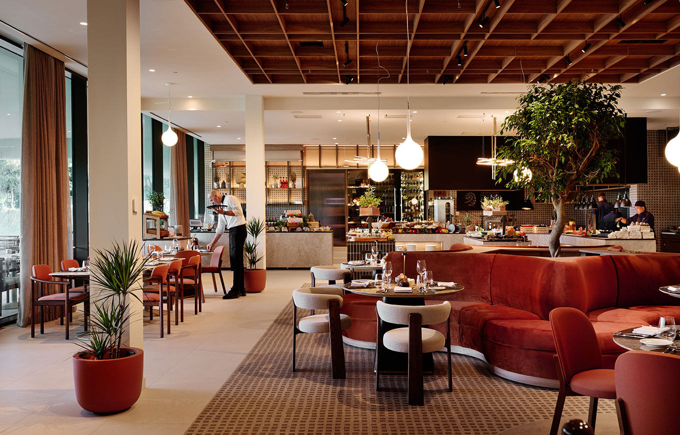 Ein modernes Restaurant mit stilvoller Einrichtung, einem großen Buffet und einem aufmerksamen Kellner.