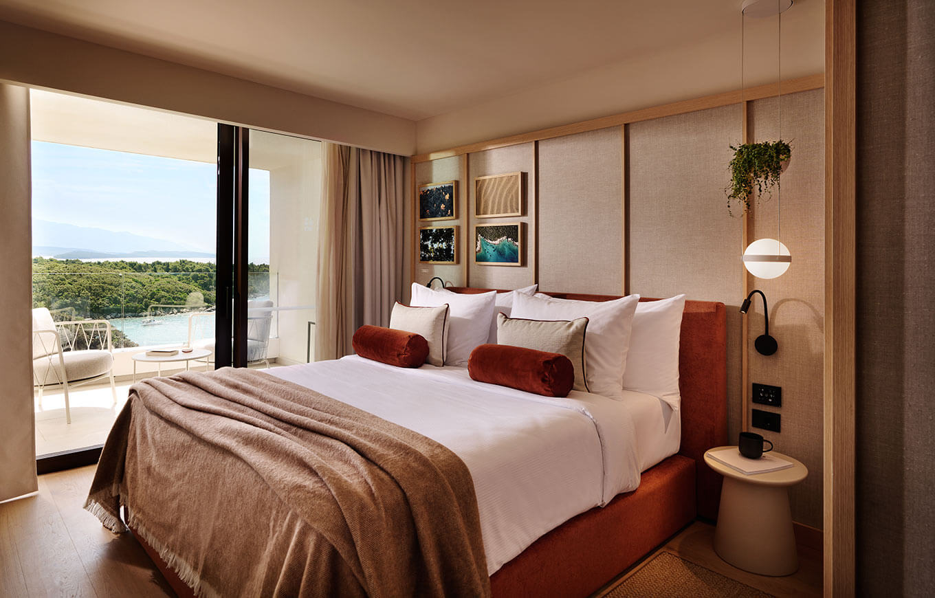 Helles, stilvolles Schlafzimmer mit Blick auf die Natur, gemütlichem Bett und modernem Interieur.