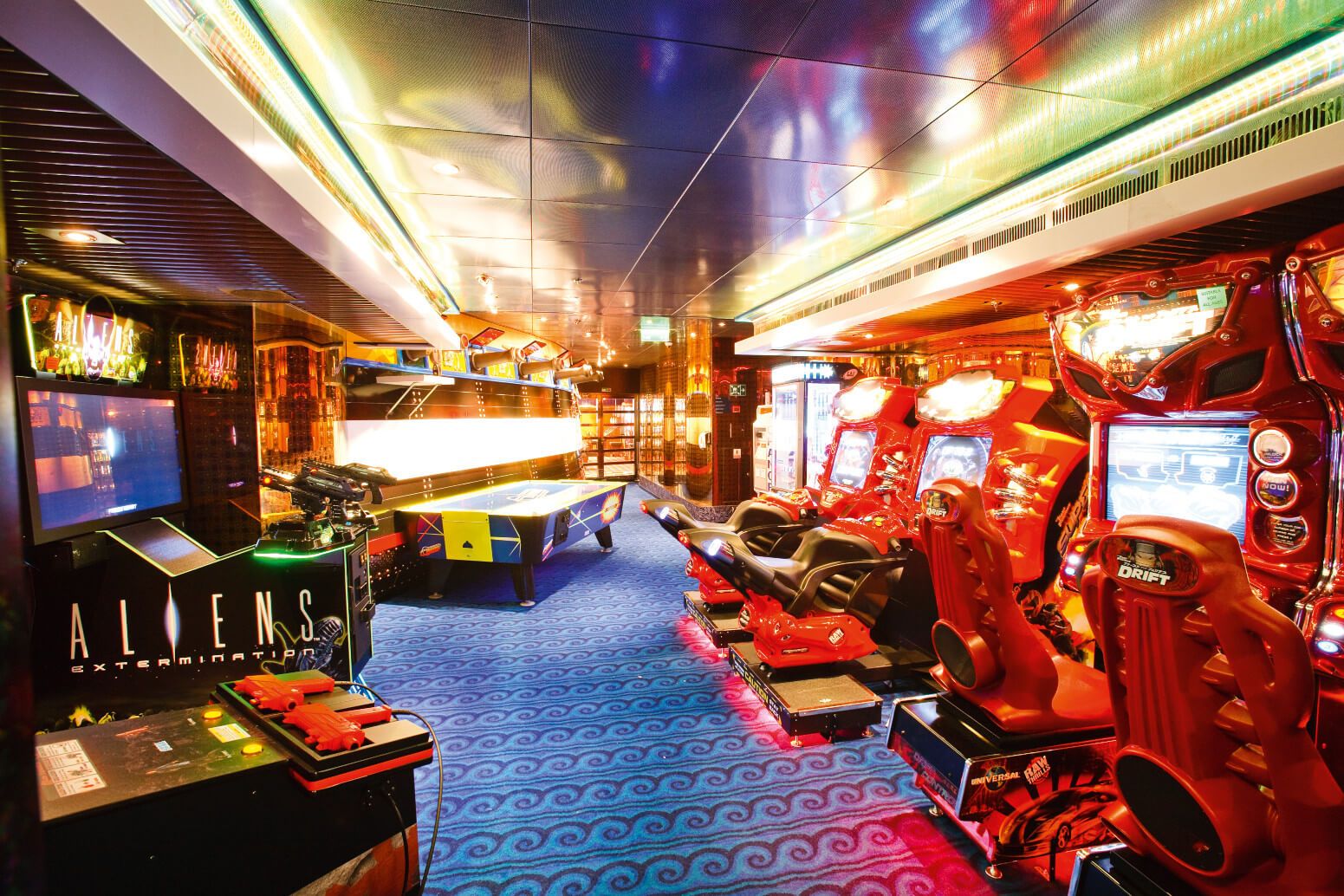 Ein modernes Spielzimmer mit leuchtenden Maschinen, Rennspiel-Sitzplätzen und einem futuristischen Ambiente.