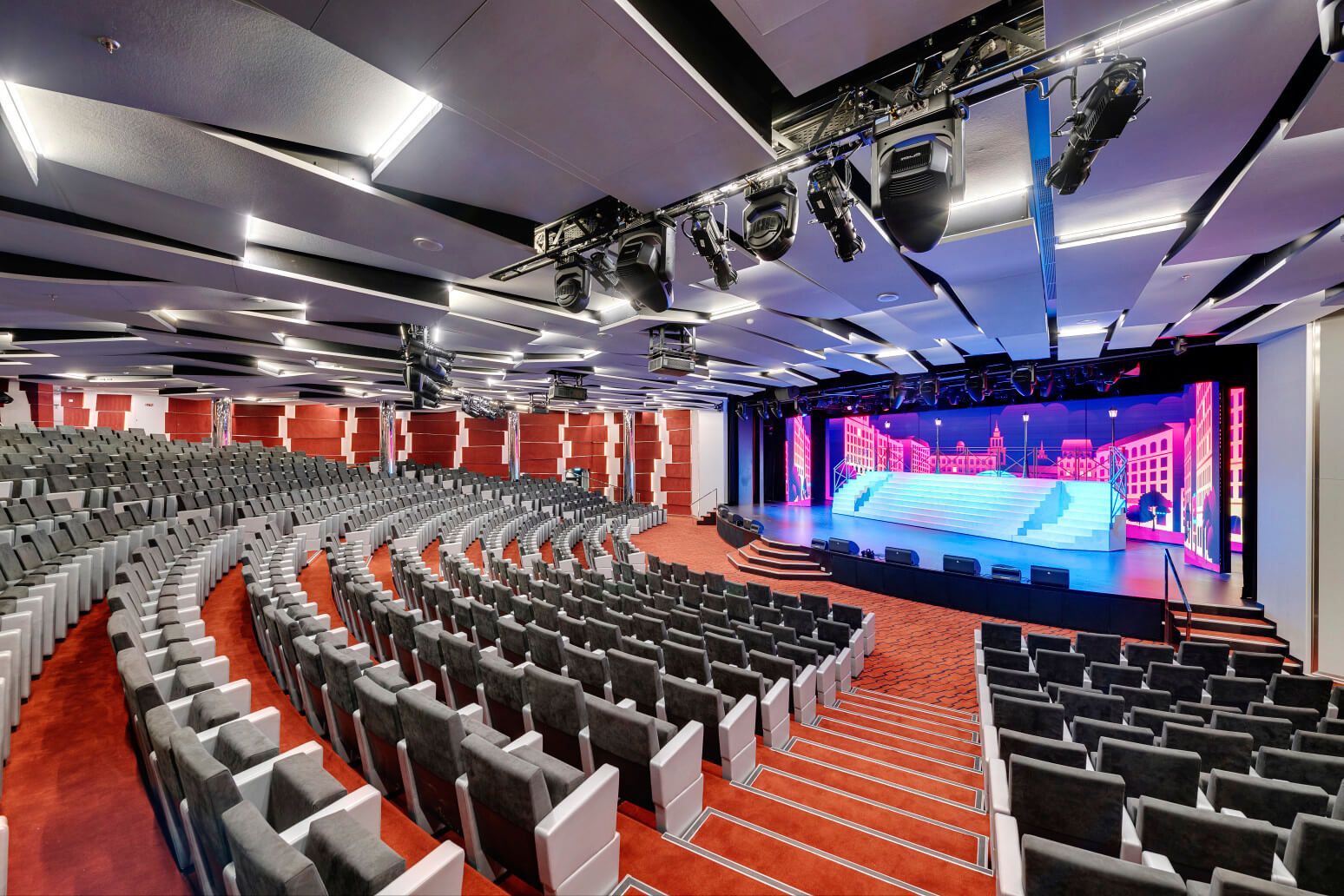 Eine moderne Theaterbühne mit Sitzreihen und beeindruckender Beleuchtung. Ideal für Veranstaltungen.