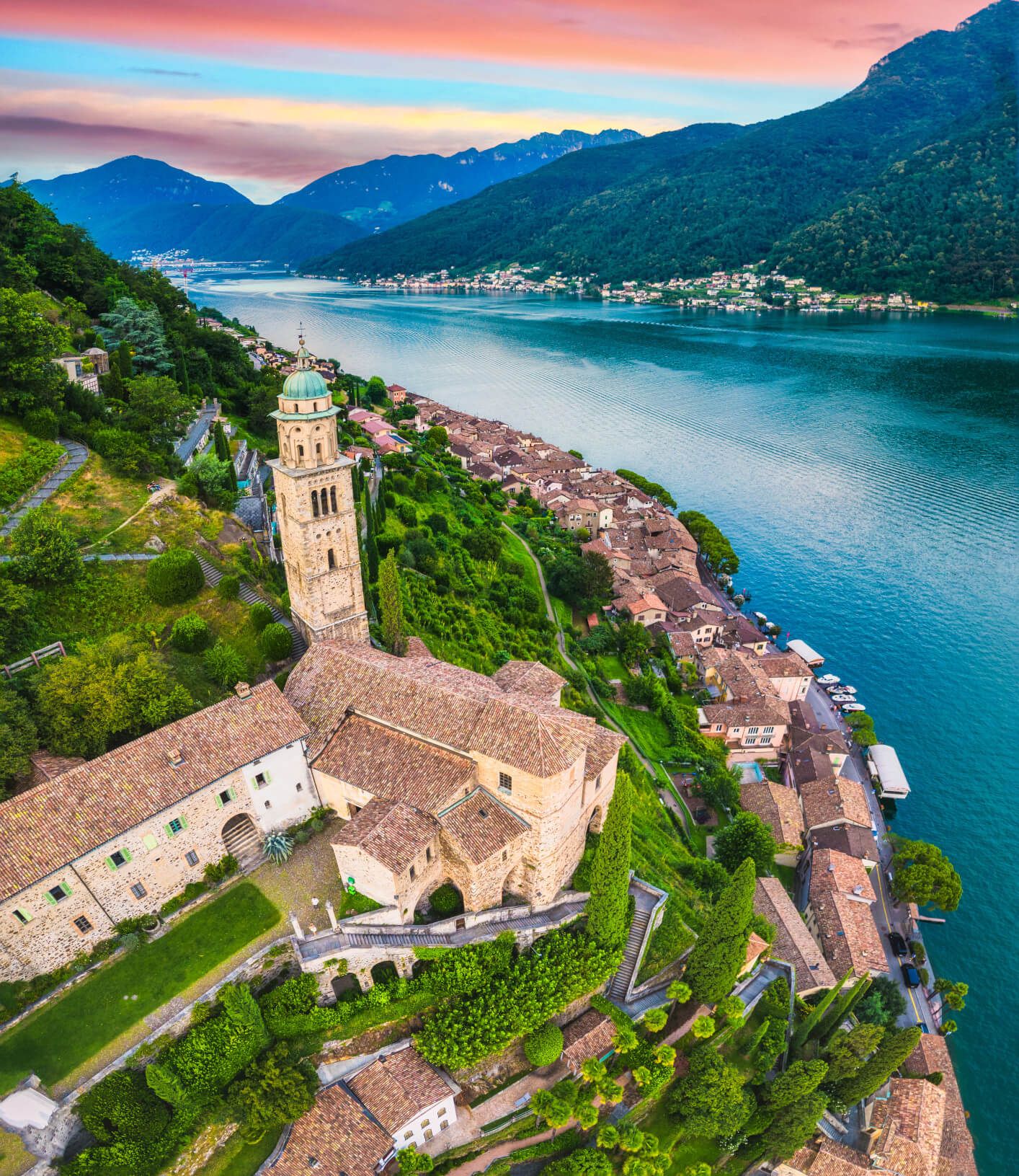 Eine malerische Landschaft mit einem historischen Gebäude, umgeben von Bergen und einem ruhigen Gewässer.
