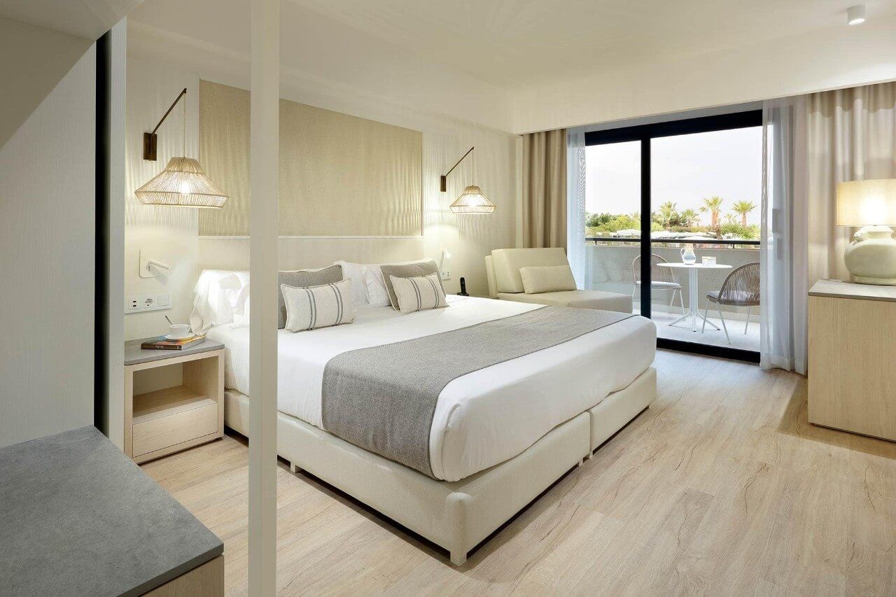 Helles, modernes Hotelzimmer mit Doppelbett, Balkon und elegantem Mobiliar. Entspannung und Komfort pur.