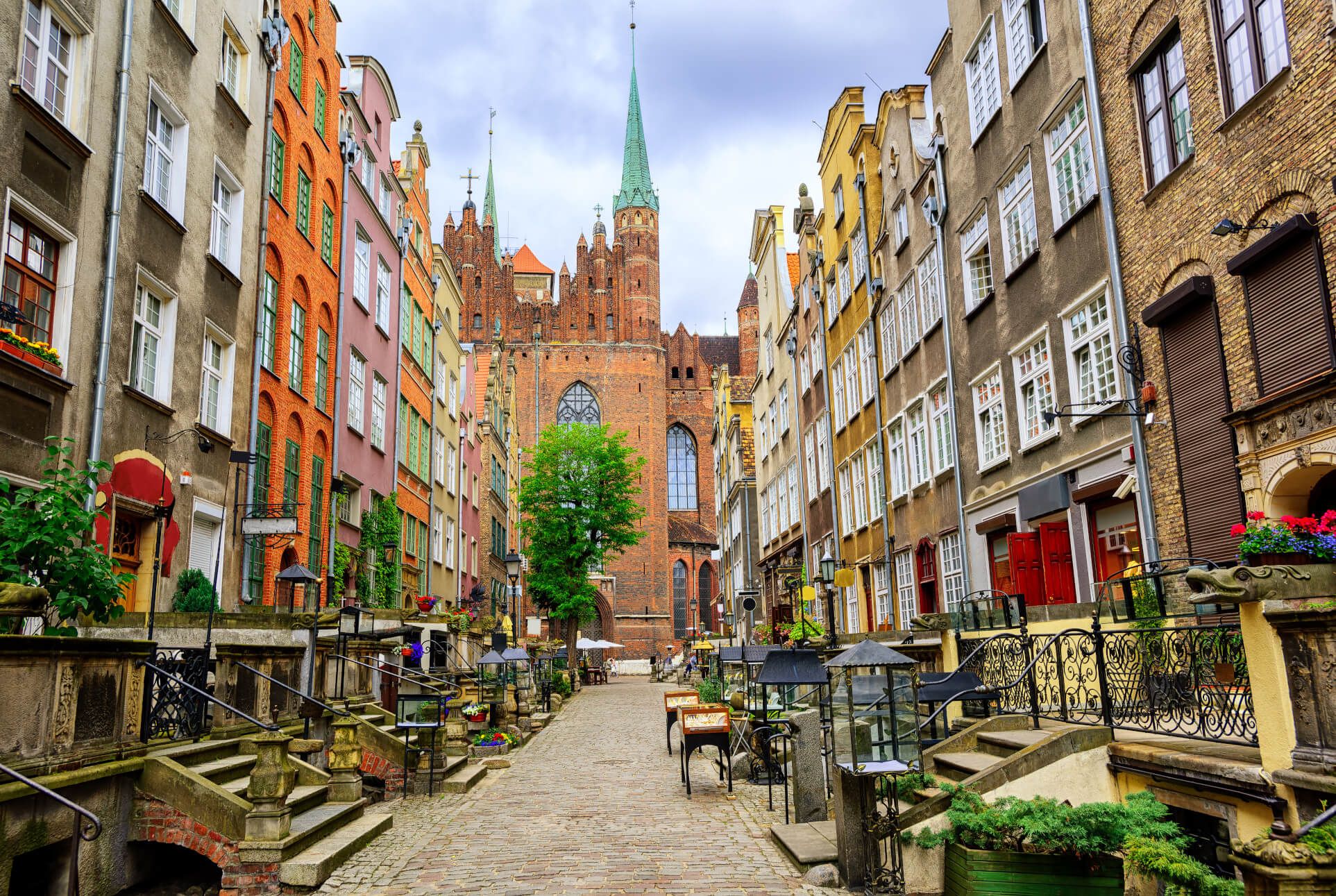 Eine wunderschöne alte Gasse mit bunten Häusern und einer beeindruckenden Kirche im Hintergrund.