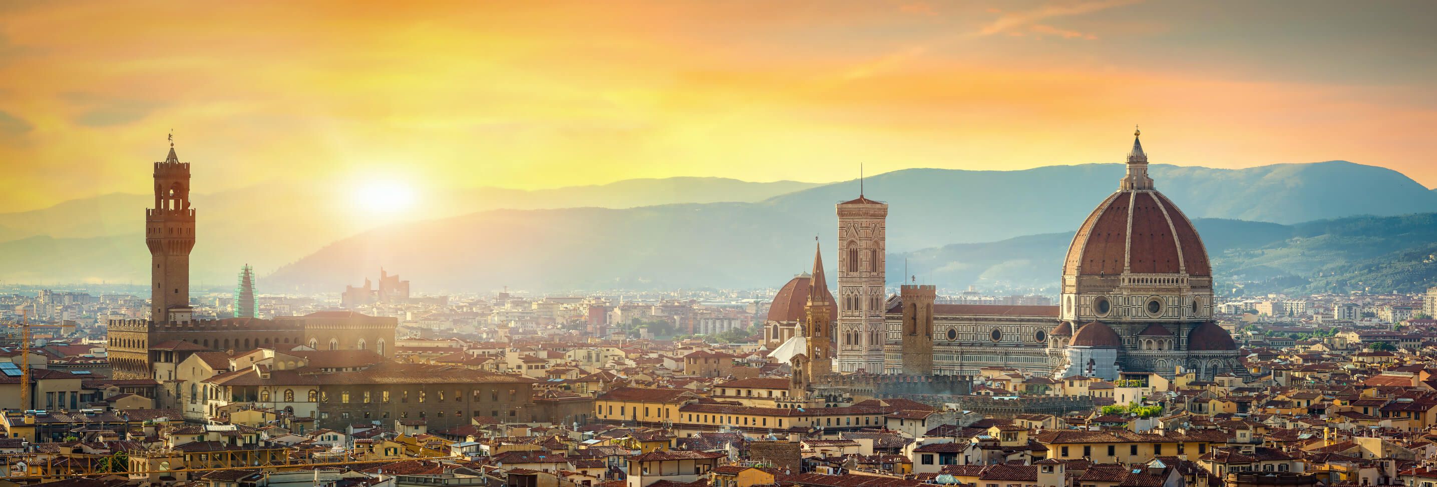 Florenz bei Sonnenaufgang, mit berühmten Gebäuden und einer malerischen Stadtansicht vor den sanften Hügeln.