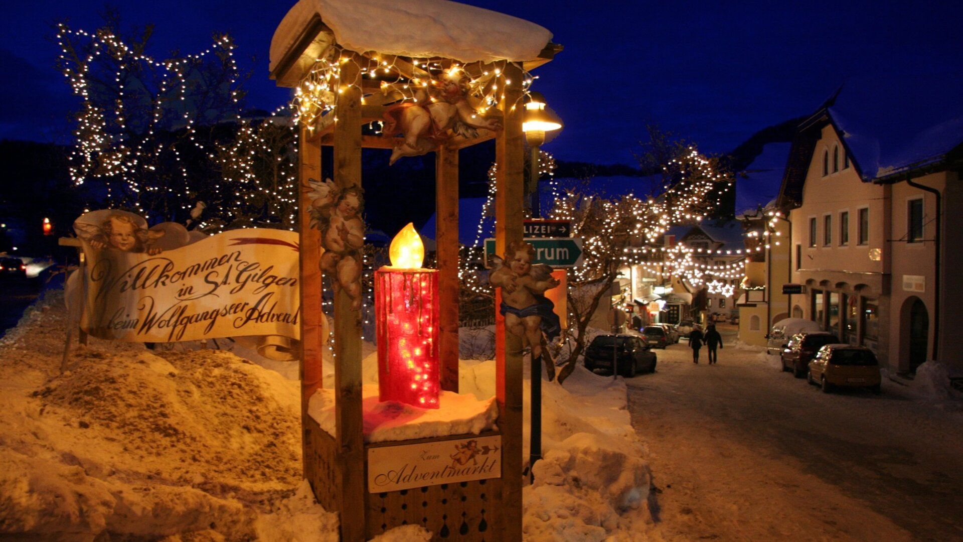 Ein winterlicher Abend in St. Gilgen mit festlicher Beleuchtung und einem großen Adventskalender.