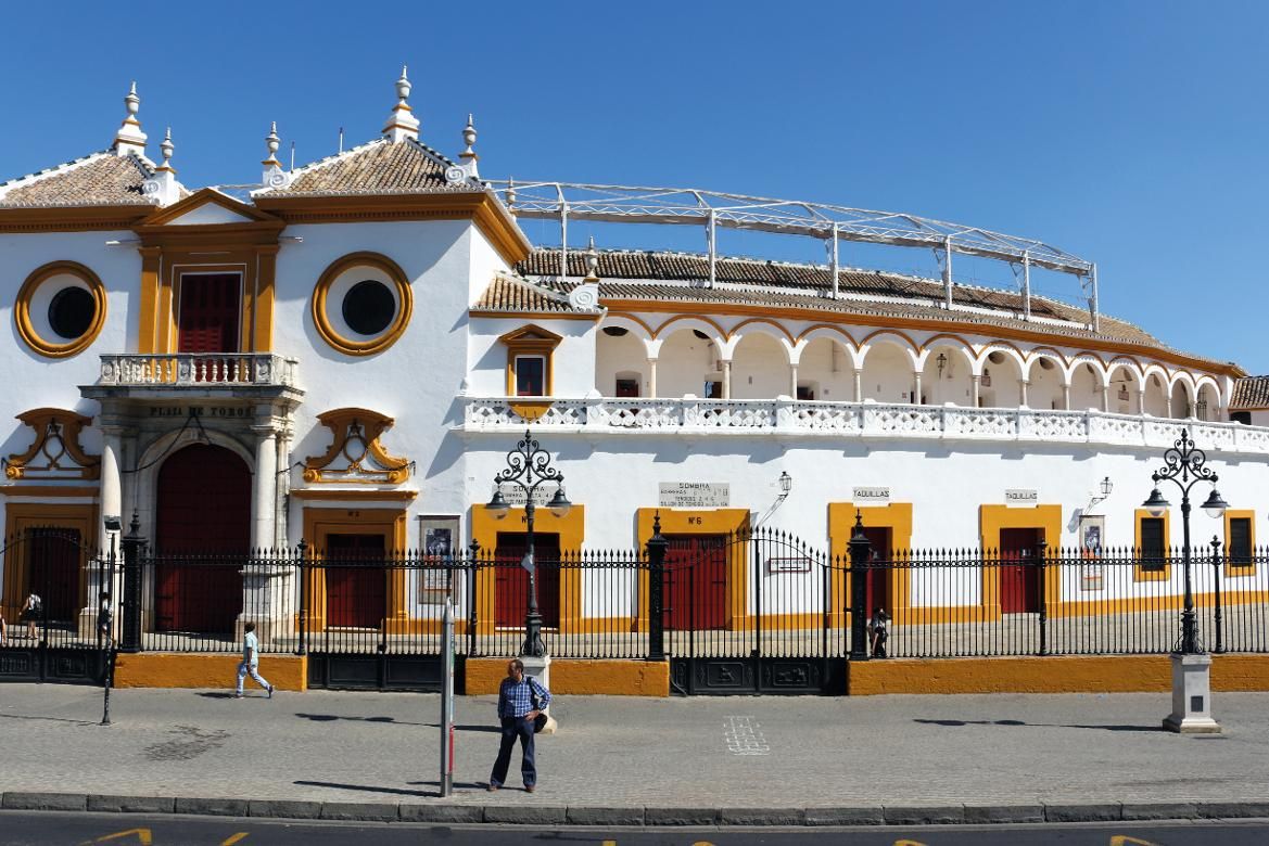Eine beeindruckende Stierkampfarena mit weißer Fassade und bunten Akzenten unter blauem Himmel.