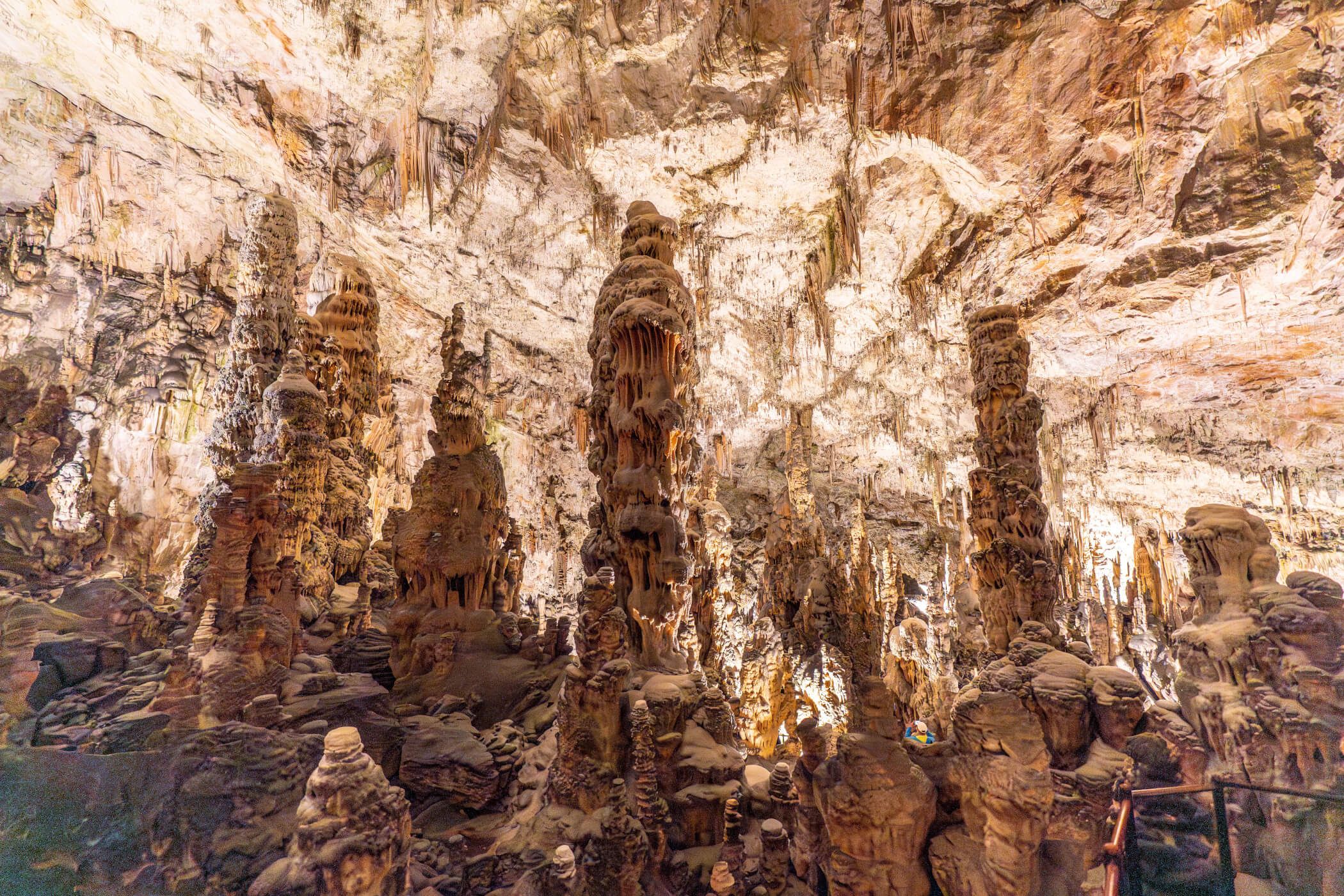 Eine faszinierende Höhlenlandschaft mit beeindruckenden Stalagmiten und Stalaktiten, beleuchtet von sanften Lichtern.
