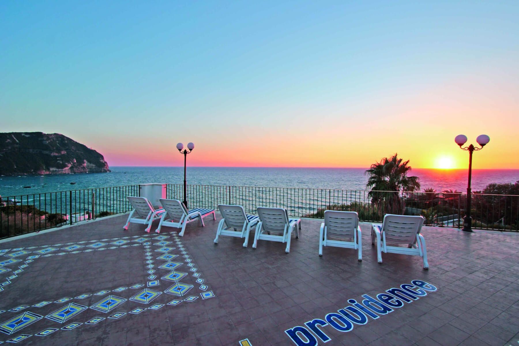 Ein schöner Ausblick auf das Meer bei Sonnenuntergang, Liegen und Palmen im Vordergrund. Entspannung pur!