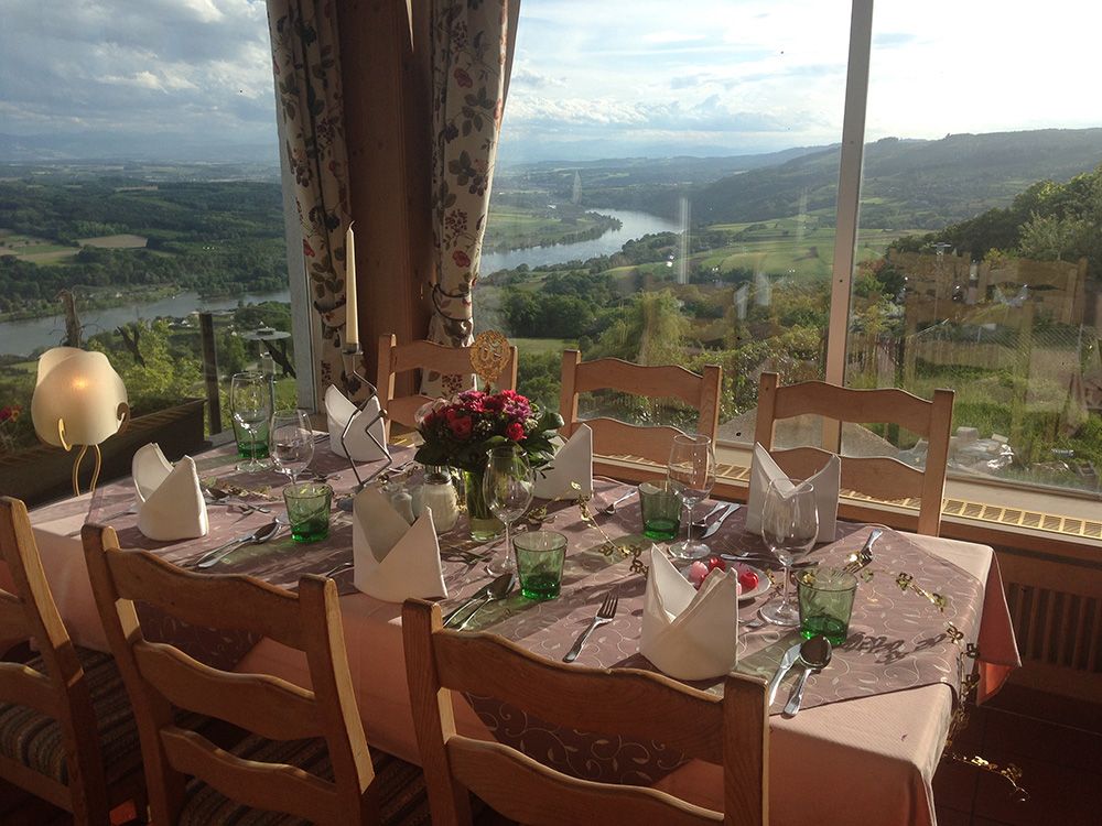Ein liebevoll gedeckter Tisch mit Blick auf eine malerische Landschaft und einen Fluss. Ideal für Anlässe.